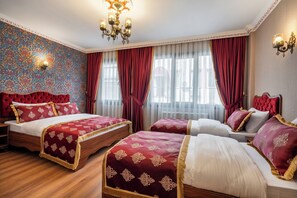 A hotel room with two beds, red and white bedding, a patterned wall, and a chandelier. - Hanchi BY Ottoman Suites (İstanbul)