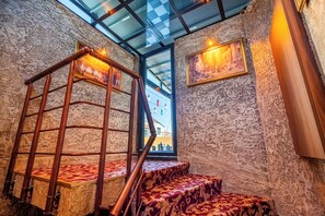 Eine Treppe mit Holzwandhandlauf und gemustertem Teppich, die zu einem Raum mit strukturierter Wand und einem gerahmten Gemälde führt.
