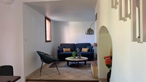 A living room with a sofa, a chair, a coffee table, and a lamp. - House 10 minutes walk from the sea (Martigues)