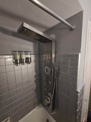 A bathroom with a shower, a hand dryer, and a towel rack. - Secluded Property w Pool and Hot Tub (Old Jamestown)