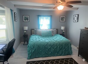 A bedroom with a bed, a desk, a chair, a dresser, a ceiling fan, and a window with curtains. - Secluded Property w Pool and Hot Tub (Old Jamestown)