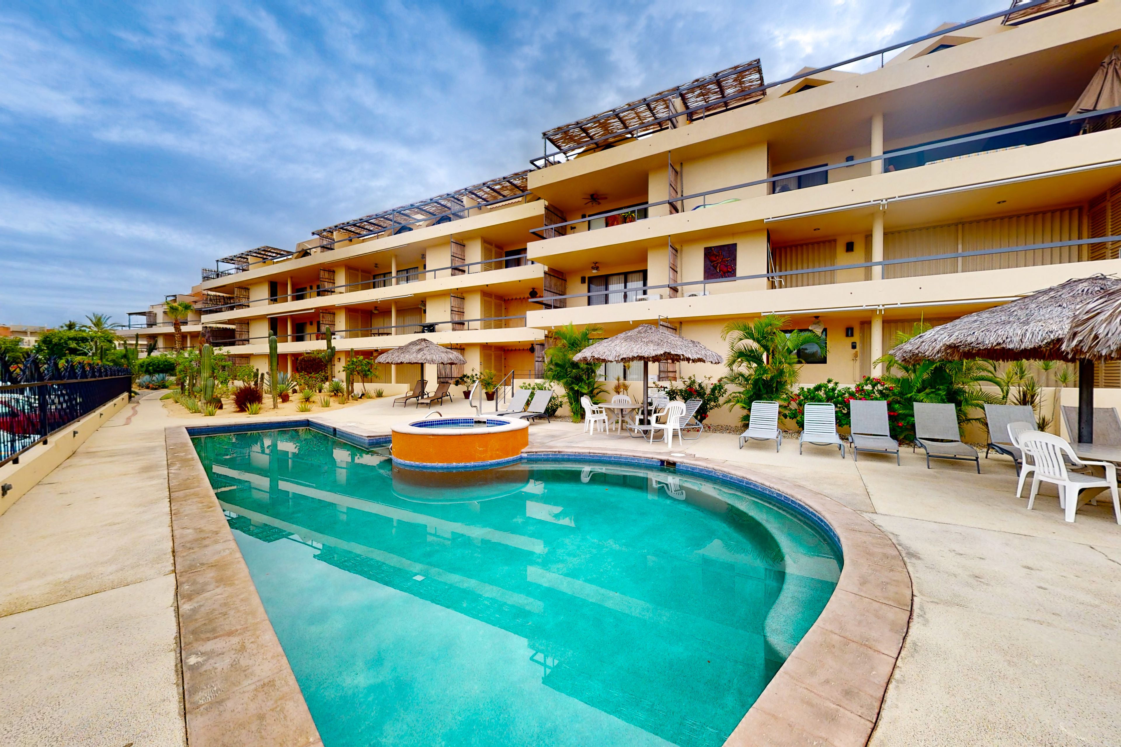 Hotel amb piscina, múltiples balcons i zones d'estar a l'aire lliure.