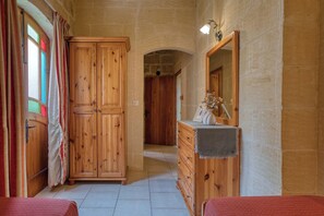 A room with a wooden wardrobe, a dresser, and a mirror. - Tan Nannu 5BDR Farmhouse in Xaghra by PMI Malta (Ix-Xagħra)