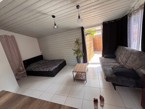 A modern loft bedroom with a bed, sofa, and a small table. - Vrbo Property (Pornic)