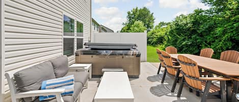 Un patio al aire libre con una parrilla, mesa de comedor, sillas y un sofá.