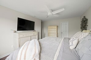 A bedroom with a bed, a dresser, a television, a door, and a ceiling fan. - Modern 4BR  - Townhouse Speedway 11min - Dwntwn 19min, Hot Tub (Indianpolis)
