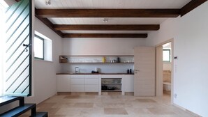 Een moderne keuken met een houten plafond, een ingebouwd spoelbak en een aanrecht met verschillende keukenbenodigdheden.