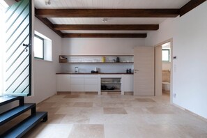 A modern kitchen with a wooden ceiling, a built-in sink, and a countertop with various kitchen items.