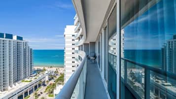 A balcony with a view of the ocean and other buildings.