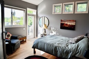 Une chambre à coucher avec un lit, une chaise, une lampe, un miroir et un tableau.