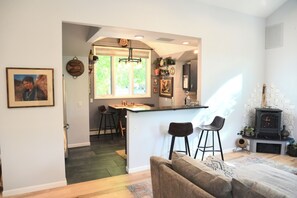 Une cuisine moderne dotée d’un bar, d’un espace repas et d’un coin salon confortable avec une cheminée.