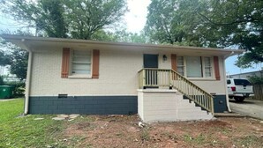 A single-story house with a front porch and a staircase leading to the entrance.