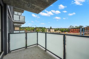 Ein Balkon mit Blick auf Gebäude und einen klaren Himmel.