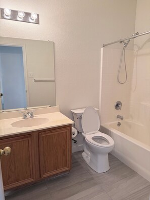 A bathroom with a sink, toilet, and bathtub.