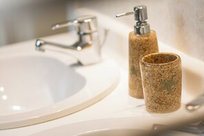A bathroom sink with a chrome faucet and a soap dispenser. - Vrbo Property (Middelkerke)