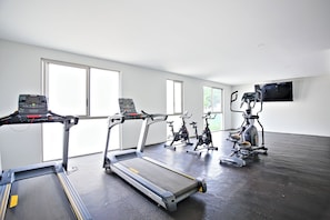 A gym with treadmills, stationary bikes, and an elliptical machine. - Black & White Apartment, an oasis in Cuernavaca (Cuernavaca)