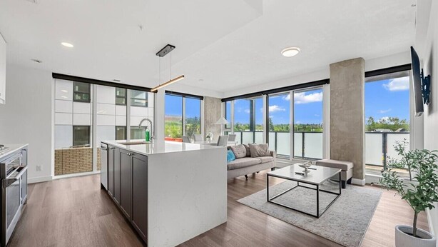 Ein modernes Apartment mit Küche, Wohnbereich und großen Fenstern.