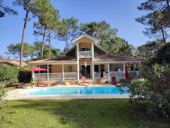 A two-story house with a swimming pool, surrounded by trees and greenery. - Vrbo Property (Lacanau)