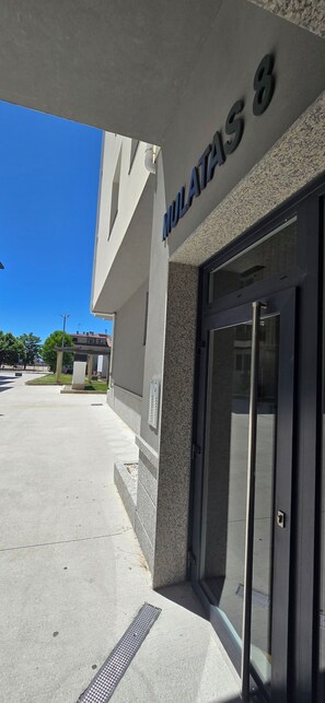 A building entrance with a glass door and a sign reading 'MULATAS 8'.
