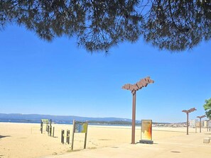 A beach with a signpost, a map, and a lifeguard tower. - Vrbo Property (Vilagarcía de Arousa)