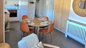 Zona pranzo con tavolo rotondo, sedie e lampadario.