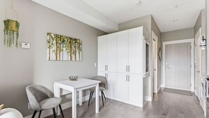 Une cuisine moderne avec des meubles blancs, une table à manger et des chaises.