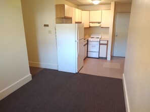 A small kitchen with a refrigerator, stove, and oven.