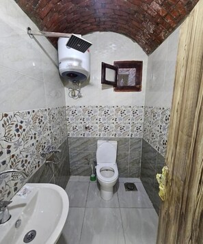 A bathroom with a toilet, sink, and a security camera. - ABU Guest House (Aswan)