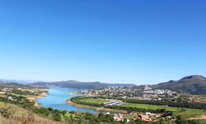 Un río serpentea por un pueblo con edificios y colinas al fondo.