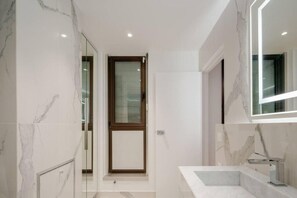 A modern bathroom with a marble floor, a glass shower enclosure, and a large mirror. - Elysee's Residence / Luxury 1 Bed Serviced Apartment (Paris)