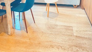 Una habitación moderna con una mesa de comedor, sillas, un sofá y una pequeña mesa blanca.
