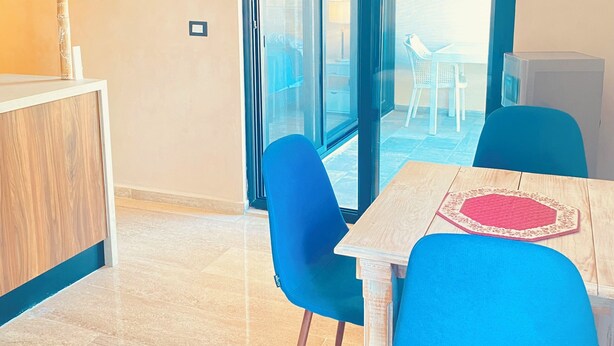 Comedor con mesa, sillas y vista a través de un ventanal.