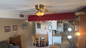 Un espacio habitable compacto con comedor, kitchenette y zona de estar.