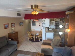 Un espace de vie compact comprenant un coin repas, une kitchenette et un espace détente.