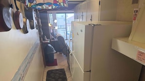Una cocina estrecha con un refrigerador, estufa y pileta.
