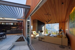 Um interior moderno com área de refeições, sofá e lareira.