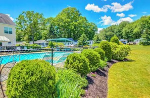 Un quartier résidentiel doté d’une piscine, entouré de pelouses et d’arbres bien entretenus.