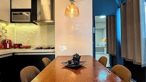 Eine moderne Küche mit einem Holztisch, einer Pendelleuchte und einer Mikrowelle.