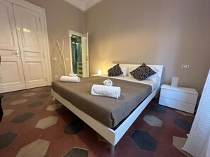 A bedroom with a bed, bedside tables, a wardrobe, and a bathroom visible through an open door. - VATICANO ROMA GUESTHOUSE (Rome)