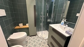 A bathroom with a toilet, shower, sink, and mirror. - VATICANO ROMA GUESTHOUSE (Rome)