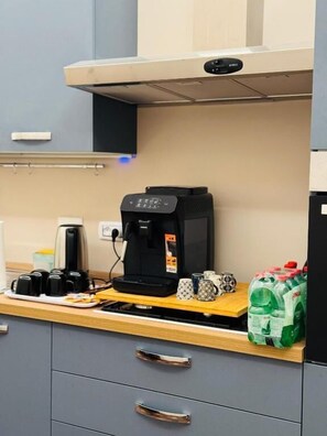 A kitchen with a coffee maker, a toaster, and a kettle on the counter. - VATICANO ROMA GUESTHOUSE (Roma)