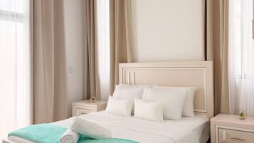 Une chambre à coucher avec un lit, des tables de chevet et des rideaux.