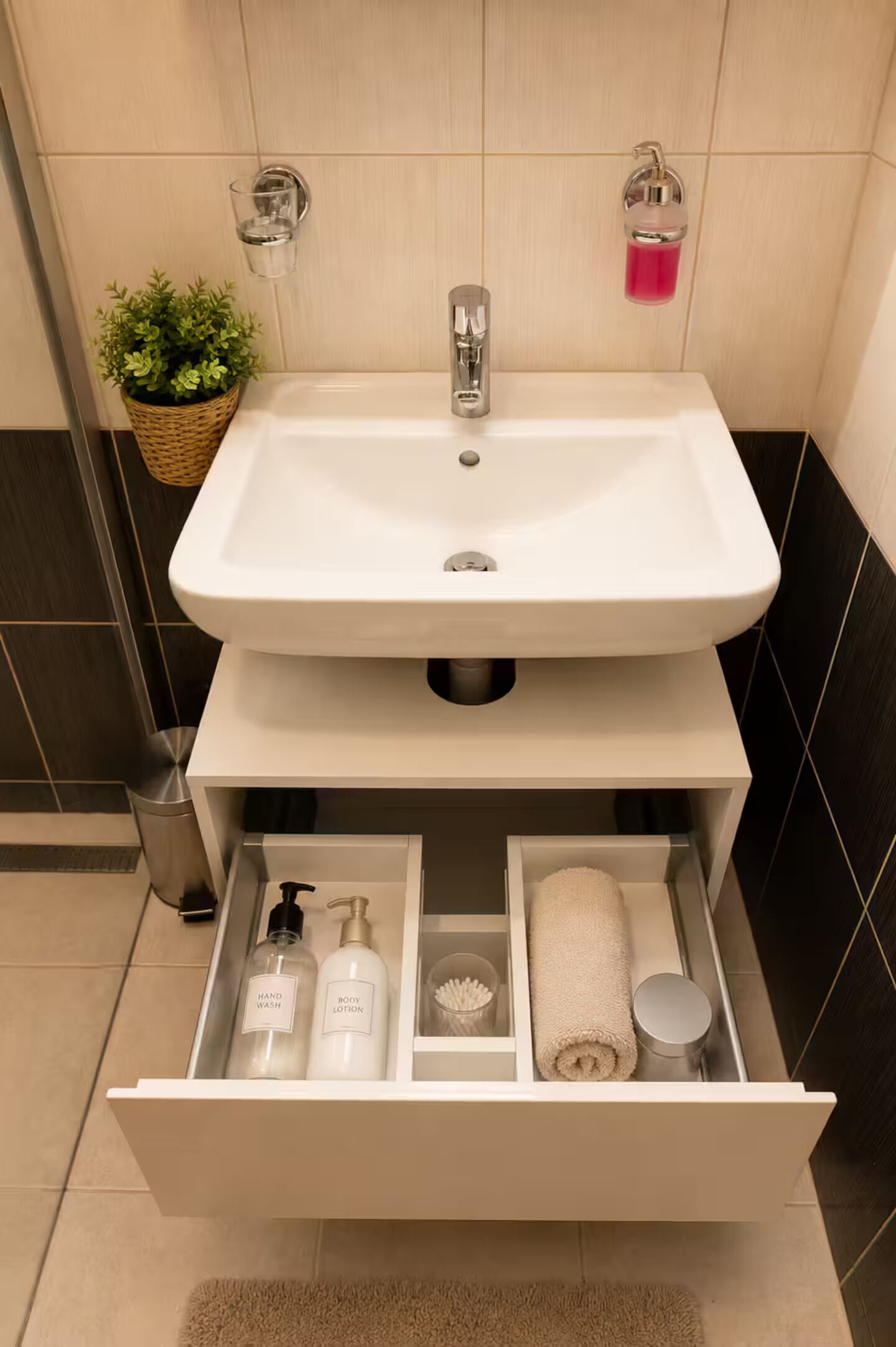 A bathroom with a white sink, a towel, and a drawer containing toiletries.