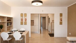 A modern living room with a dining area, a sofa, and a coffee table. - Apartment Pred Polom (Trenčín)