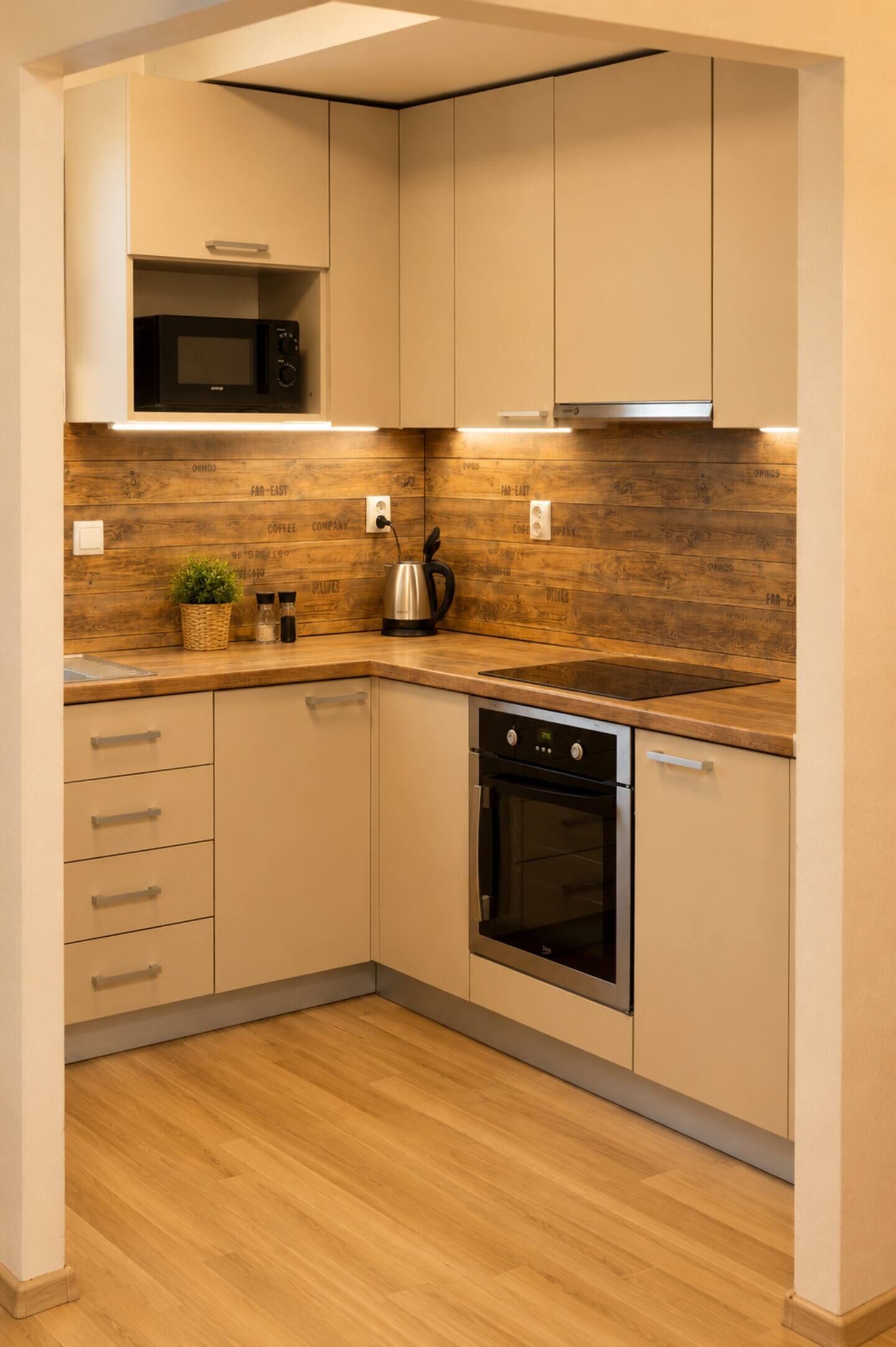Cocina compacta con microondas, horno y armarios empotrados.
