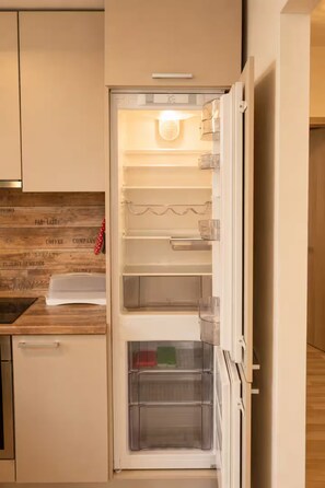 An open refrigerator with shelves, a freezer compartment, and a water dispenser.