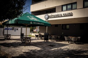 Ravintola, jossa on ulkoterasseja, vihreä aurinkovarjo ja kyltti, jossa lukee ”RESTAURACIA HALONG”.
