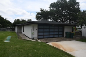 A single-story house with a garage, a front yard with stepping stones, and a tree. - Cozy lakefront retreat with kayaks, fishing, and extra parking! (Marble Falls)