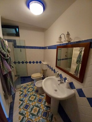 Ein Badezimmer mit Toilette, Waschbecken und Spiegel.
