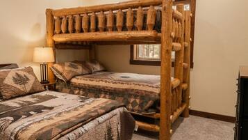 Una cama litera con estructura de madera y una ventana encima.